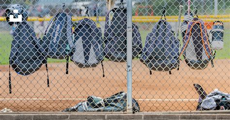 Un Terrain De Baseball Avec Un Tas De Vêtements Accrochés à Une Clôture