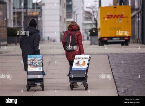 Two Jehovah S Witnesses With Brochures On Trolleys During Street