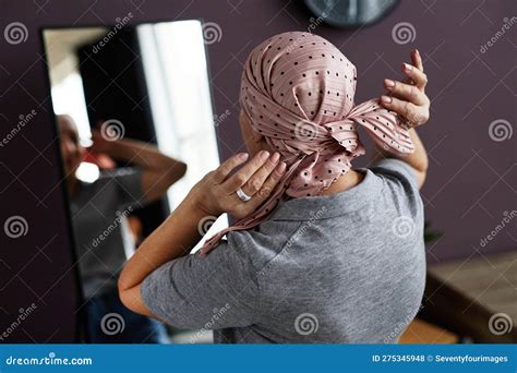 Back View Of Unrecognizable Bald Woman Tying Headscarf Stock Photo