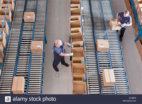 Workers packing boxes on conveyor belts in distribution warehouse Stock Photo: 52342829 - Alamy