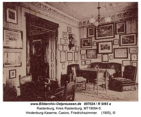 An Old Black And White Photo Of A Living Room With Pictures On The Wall