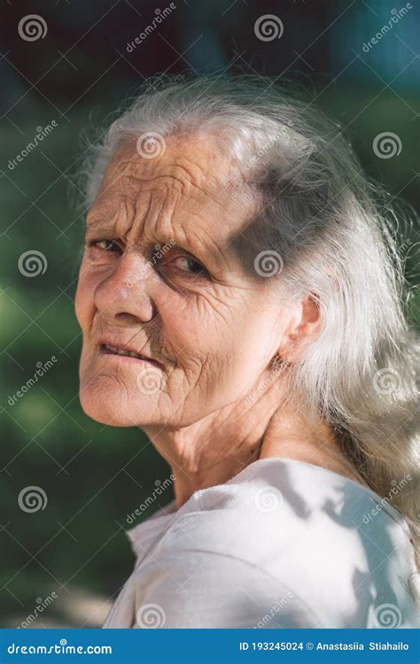 Portrait Of A Gray Haired Adult Grandmother Against The Background Of