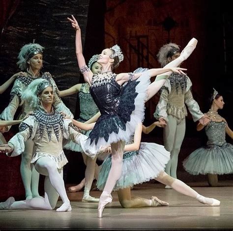 Ballet Dancers In Tutu Skirts And Headdresses On Stage With One Holding