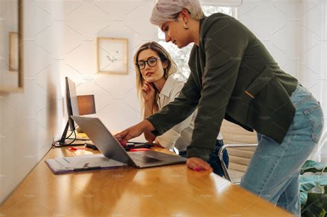 Female Business Partners Working Together In An Office By Jacob Lund On