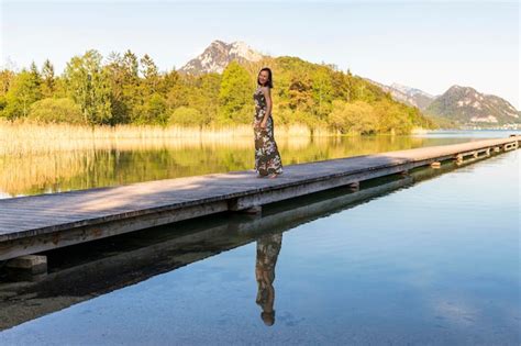 Premium Photo Portrait Of Smiling Woman Standing On Pier Over Lake