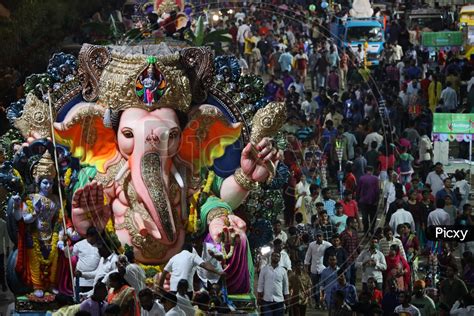 Image Of Ganesh Idols In Trucks And Crowd Of Devotees At Tank Bund For