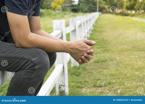 Man Sitting On Long Fence And Crossed His Fingers Stock Image Image