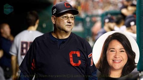 A Man And Woman Standing Next To Each Other At A Baseball Game