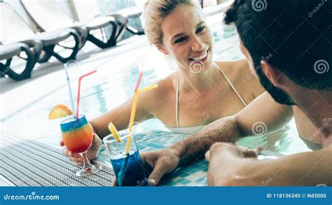 Pares Atractivos Felices Que Se Relajan En Piscina Foto De Archivo