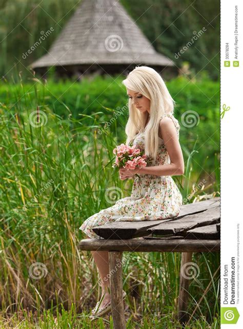 Jeune Fille S Asseyant Sur Un Banc En Bois Par Le Lac Photo Stock