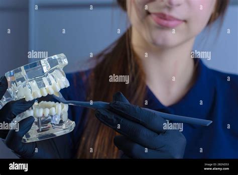 Close Up Of A Dentist Doctor Smiling Wearing Gloves Holding In His