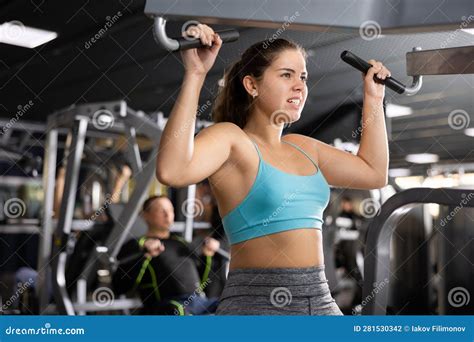 Young Woman Trains Her Arm Muscles Using a Simulator in Gym Stock Photo ...