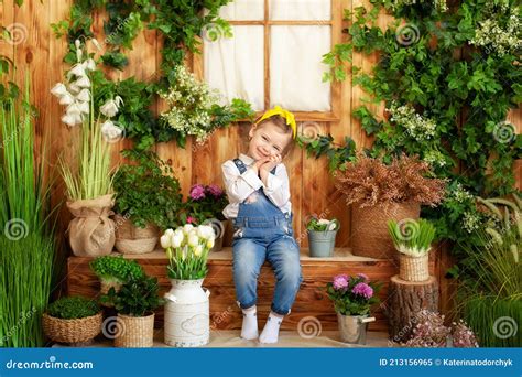 Une Petite Fille En Salopette Est Assise Sur Un Porche De Maison En