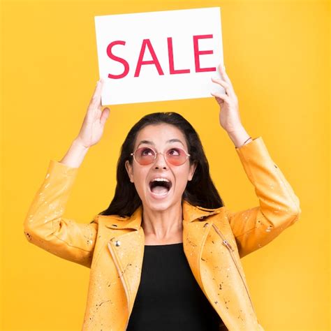 Free Photo Woman In Yellow Jacket Holding A Sale Banner Medium Shot