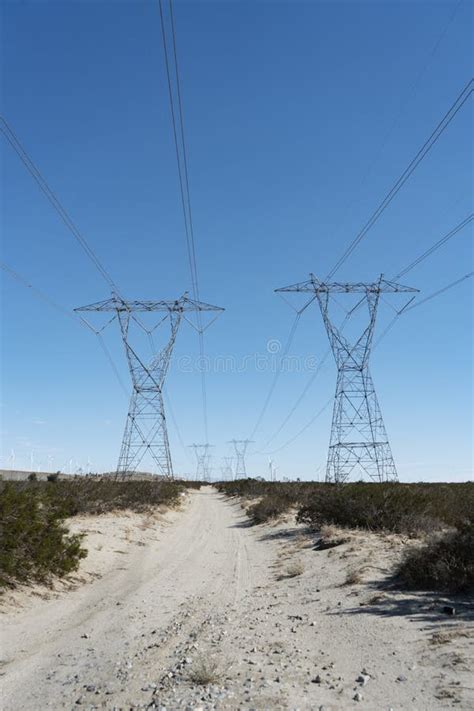 High Tension Power Towers And Lines Stretching Across Desert Stock