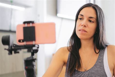 Joven latina haciendo una videollamada a través de su teléfono celular sostenido por un cardán