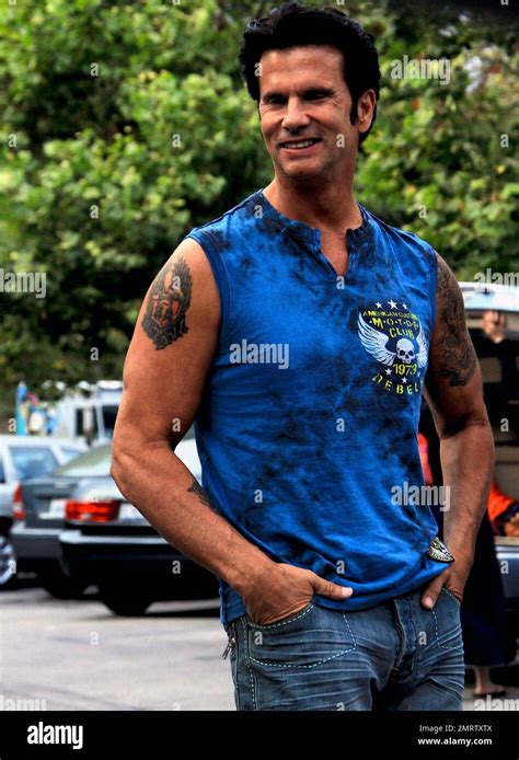 Wearing A Sleeveless Blue T Shirt Showing Off The Tattoos On His Arms Lorenzo Lamas Smiles