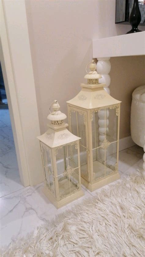 Two White Lanterns Sitting Next To Each Other On A Rug