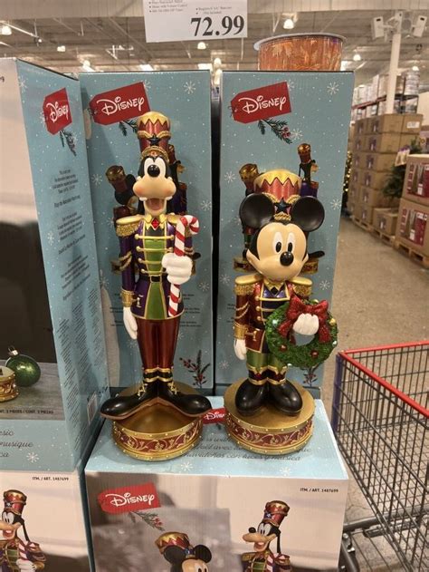 Two Mickey Mouse Figurines Are On Display In A Store With Christmas