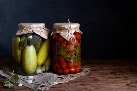 Pepinos Y Tomates Enlatados En Un Frasco Sobre Una Mesa De Madera