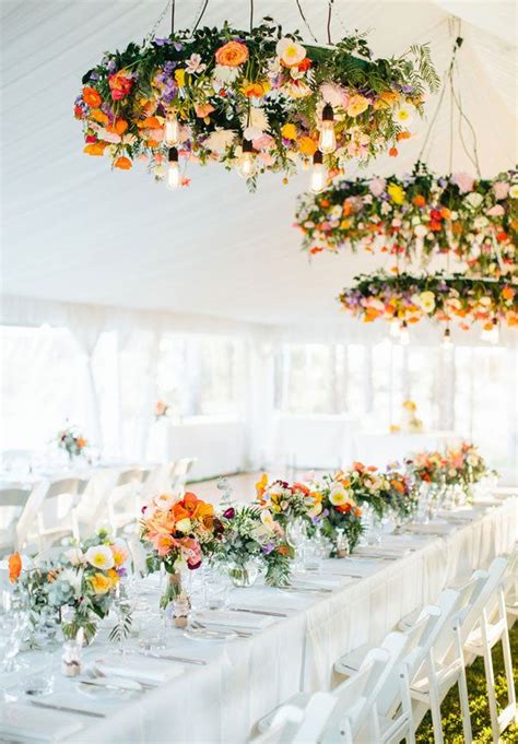 The Tables Are Set With White Linens And Flowers Hanging From The