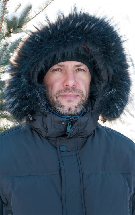 Portrait Of Confident Man Wearing Fur Hooded Parka Coat At The S Stock