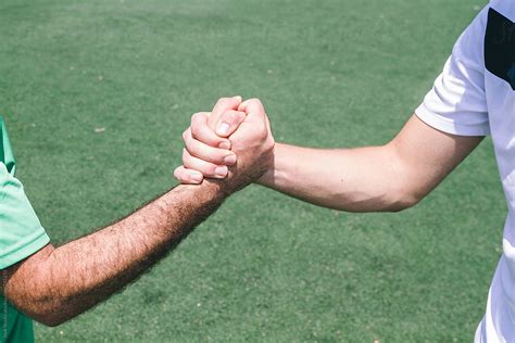 Two Soccer Players Shaking Their Hands During A Soccer Match By Stocksy Contributor Inuk