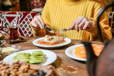 Premium Photo Woman Sitting At Table With Plates Of Food