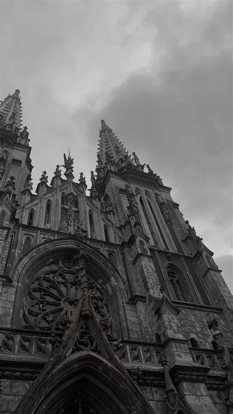 An Old Church With Steeples And Clocks On It S Front Door Against A