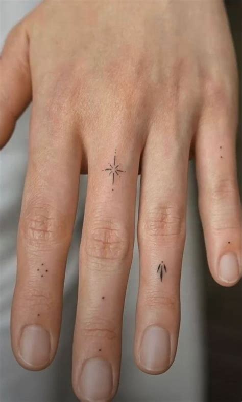 A Person S Hand With A Small Star Tattoo On The Middle Finger And An Arrow