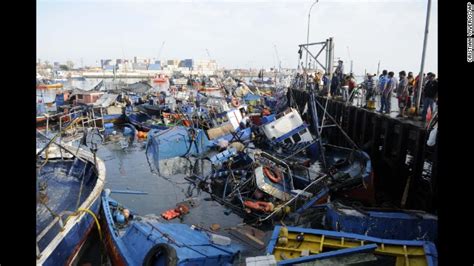 Fishing boats washed ashore by a tsunami sit in the waters of Iquique ...