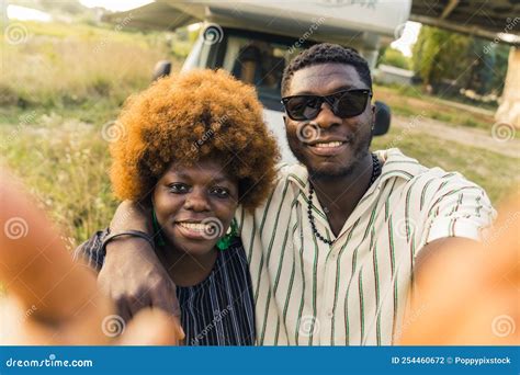 Smiling Ethnic Dark Skinned Straight Couple Having A Summer Road Trip In A Camping Van Hugging