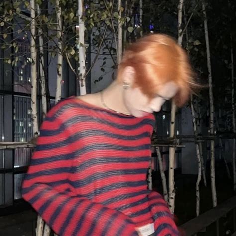 a woman with red hair wearing a striped sweater