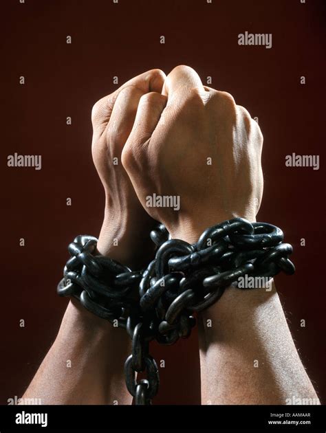 MANS HANDS FISTS TIED WITH CHAIN CHAINS PRISONER CHAINED CAPTIVE