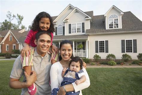 Hispanic family smiling in front of house - Healthy Balance