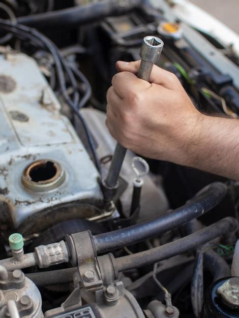 Premium Photo Car Mechanic Repairing Engine In Garage