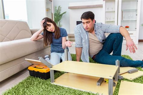 Los Muebles De Junta De La Familia Joven En La Nueva Casa Imagen De