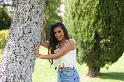 Beautiful Spanish Brunette Woman With Long Curly Hair And Big Slit Eyes Rests Her Hands On The