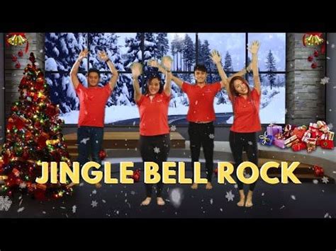 three people in red shirts standing next to a christmas tree with their ...