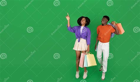 Cheerful Millennial Black Couple Shopaholics With Packages With Purchases Point Finger On Empty