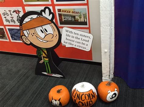 three pumpkins sitting on the floor in front of a bulletin board with ...