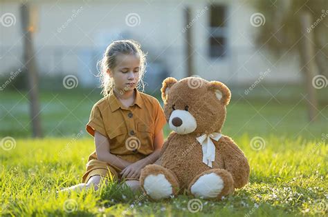 Unhappy Child Girl Spending Time With Her Teddy Bear Friend Outdoors On