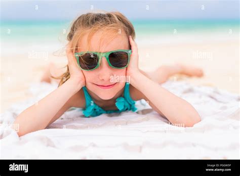 Adorable Little Girl Lying On A Beach Towel During Summer Vacation