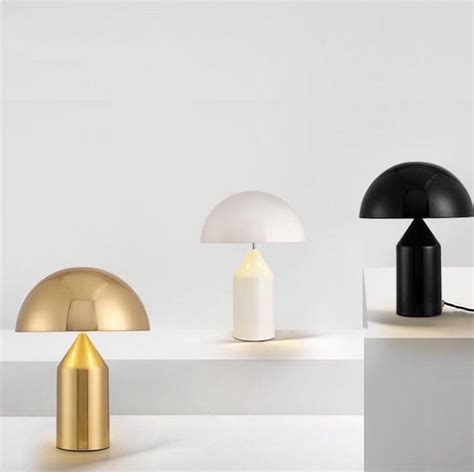 Three Different Colored Lamps Sitting On Top Of A White Table Next To