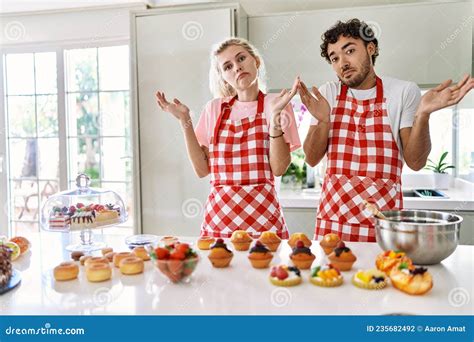 Couple Of Wife And Husband Cooking Pastries At The Kitchen Clueless And Confused Expression With