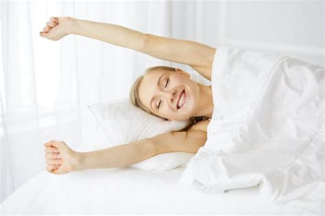 Smiling Woman Stretching Hands In Bed After Waking Up Entering A Day