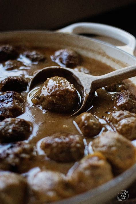 Meatballs And Gravy Are Being Stirred With A Wooden Spoon In A Pot