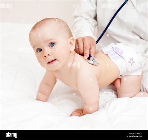 Pediatrician Examines Baby Girl Doctor Using A Stethoscope To Listen