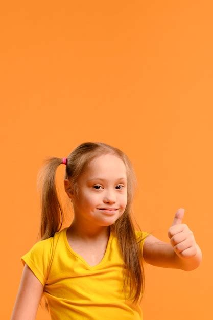 Portrait D Une Adorable Fille Avec Le Pouce Vers Le Haut Photo Gratuite