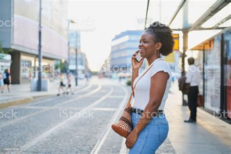 Laughing African American Woman Talking On The Phone While Waiting For